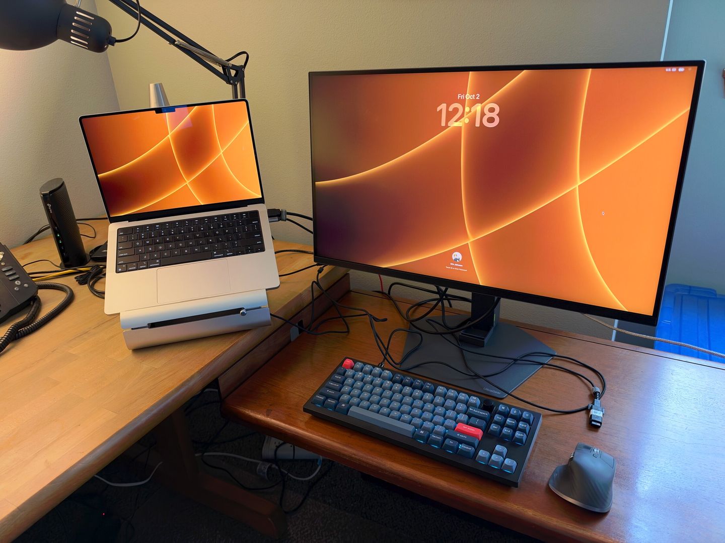 Eric's desk: a laptop on a stand beside a large monitor, a keyboard and a mouse